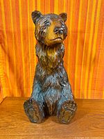 Front view of carved wooden bear showing full figure and paw details