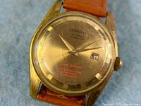 Close-up of dial showing Lograma branding, 25 jewels, waterproof text, date window