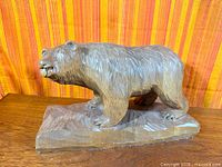 Full view of wooden bear on base