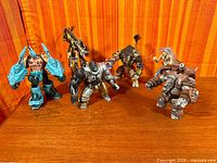 Group shot of all five loose Spawn action figures standing on wood surface