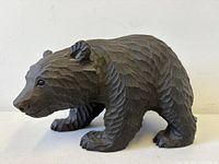 Right side view of carved wood bear showing glass eye and fur texture