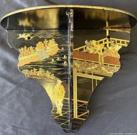 Front view showing lacquer, hinged centre, gilt scenes