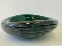 Oblique view showing oval form, green core, grey exterior with horizontal grooves