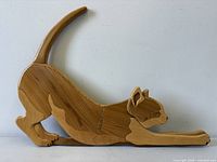 Front view of carved inlaid wood stretching cat wall art