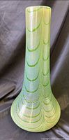 Full view of tall green iridescent vase showing neck and base