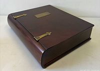 Top view showing curved spine, brass hinges, brass cartouche