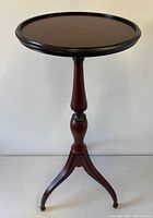 full view of table front showing round top, pedestal and legs