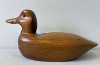 Left side view of solid wood duck decoy showing overall form and grain