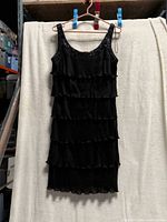 Full view of black tiered dress hanging