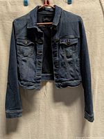 Front view of Liquid X cropped denim jacket hanging