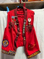Full view of red vest with pins and patches