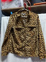 Front view of leopard print Alfred Sung blouse on hanger