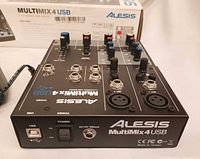 Top view of mixer showing controls, inputs and accessories, box in background