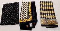 Three folded ZILLI silk scarves showing full designs