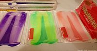 Multiple sealed bags showing purple, green, peach combs and Designer Combs label