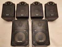 Group shot of three small Tannoy speakers and two larger Realistic speakers