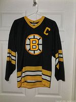 Full front view of Boston Bruins #77 jersey on hanger