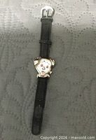 Front view showing Dalmatian-shaped case and black leather band