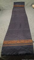 Full view of navy patterned scarf showing length and borders
