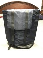 Front view of navy nylon backpack with flap and logo