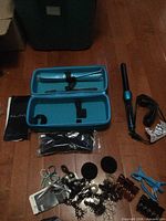 Overview of kit: travel case, curling wand, sealed glove, accessories spread out