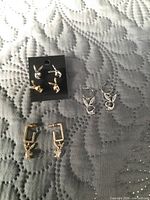 All four pairs of Playboy bunny earrings displayed on fabric background