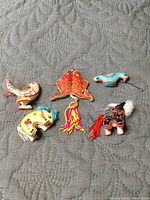 Five silk animal ornaments arranged on surface
