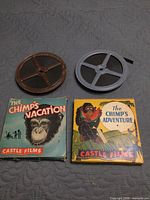 Two metal film reels and two Castle Films boxes displayed