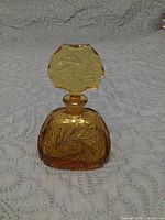 Front view of amber glass perfume bottle with stopper inserted