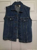 Front view blue denim vest on hanger