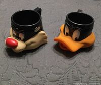 Front view of both plastic character mugs