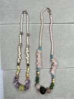 Two gemstone chip bead necklaces laid flat showing full length and clasps