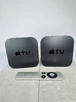 Front view of both Apple TV units and remote