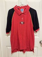 Full front view of Adidas 49ers red and black polo shirt on hanger