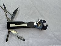 Overall view of Alcatel multi-tool with all implements extended on white background