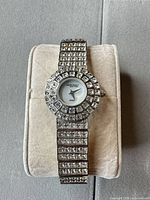 Front view of Anne Klein crystal-covered watch on display pillow