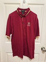 Front view of entire polo shirt on hanger