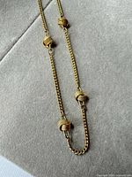 Full view of gold tone station necklace showing length and bead placement