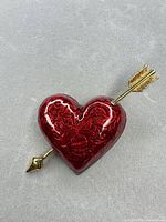 Full view of heart-shaped brooch with arrow