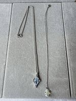 Two necklaces laid flat showing full length and pendants