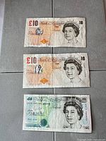 All three banknotes laid flat (£10, £10, £5)