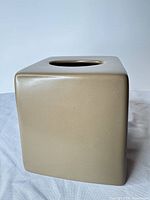 Front and side view of beige ceramic tissue box cover showing overall cube form and finish