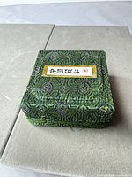 Closed green fabric presentation box with Chinese label
