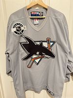 Full front view of grey San Jose Sharks CCM hockey jersey