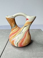 front view of small marbled ceramic vase showing dual spouts and handle
