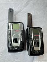 Front view of both Cobra CXR725 radios showing screens, buttons and antennas