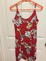 Full front view of red floral sundress on hanger