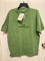 Full front view of green Crazy Shirts T-shirt on hanger