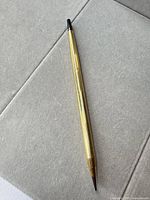 Full view of gold-filled Cross mechanical pencil on fabric surface