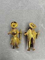 Both figural brooch pins full view